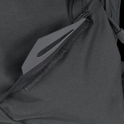 Close-up of the Condor Elite Fail Safe Urban Backpack Gen II 18L by Condor in black, featuring a partially open zipper pocket that reveals a flat, gray metal tool—perfect for bushcraft or first responder use.